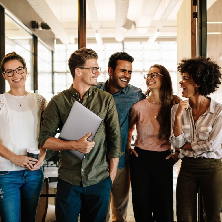Kolleg:innen laufen durch ein Büro und unterhalten sich entspannt
