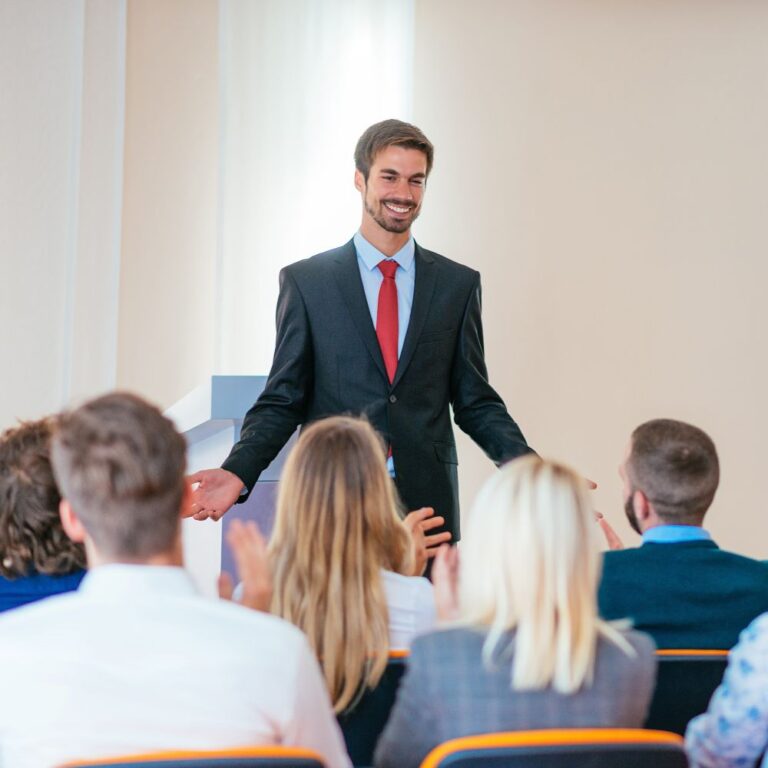 Business-Coach oder Dozent spricht vor Teilnehmenden im Seminar