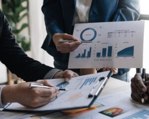 Team bespricht Diagramme und Strategien am Tisch mit Unterlagen