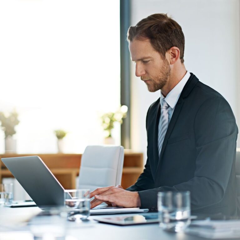 Businessmann arbeitet fokussiert mit Laptop am Schreibtisch