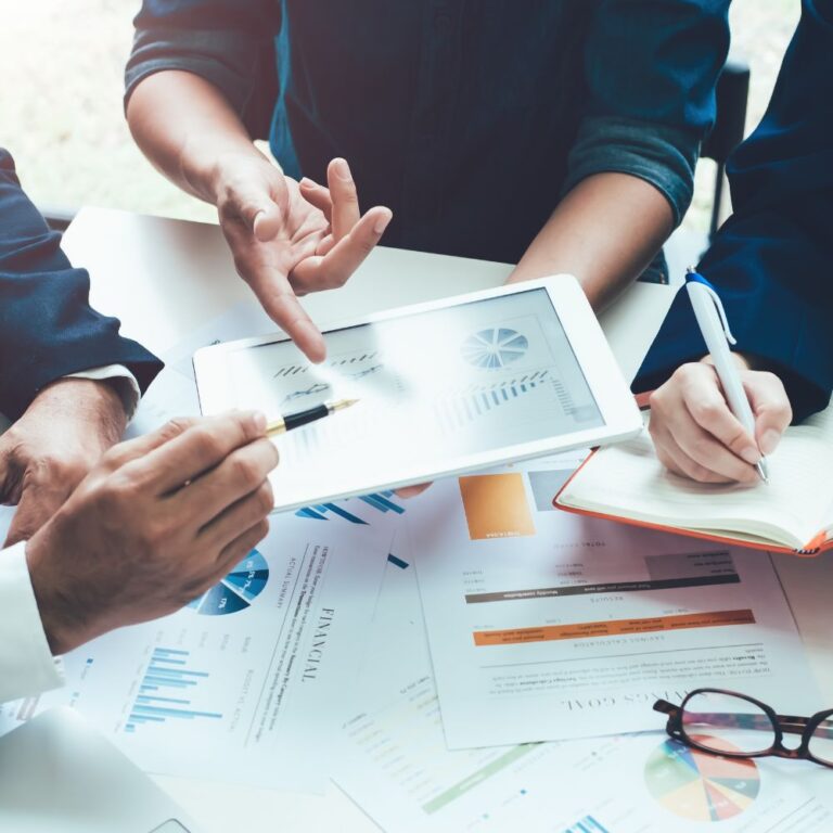 Hände mehrerer Personen arbeiten gemeinsam an Dokumenten