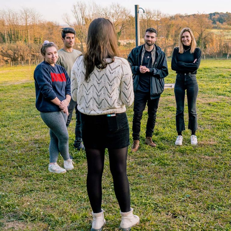 Gruppe steht in einem Kreis und unterhält sich